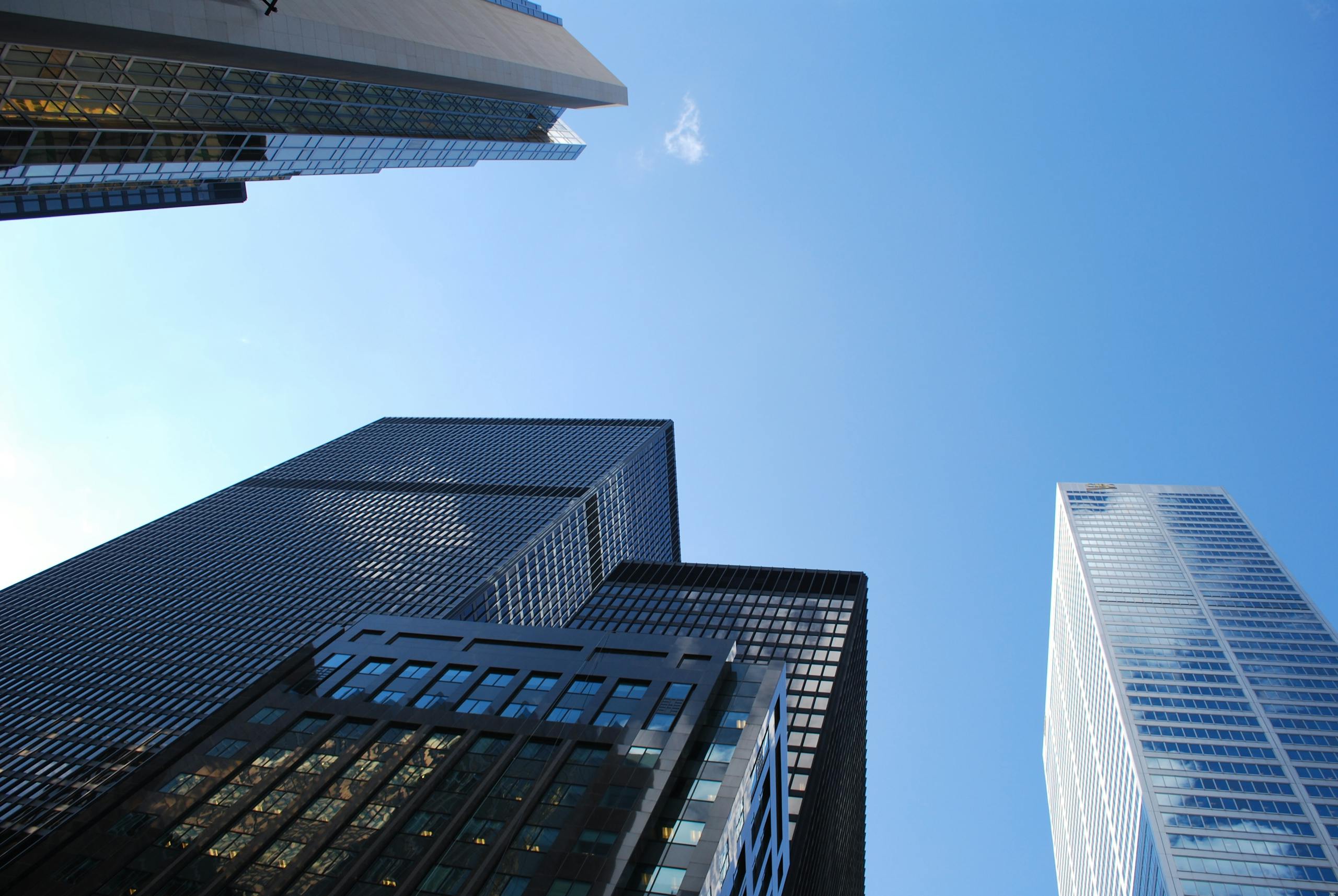 Low angle view of modern skyscrapers with a clear blue sky background.