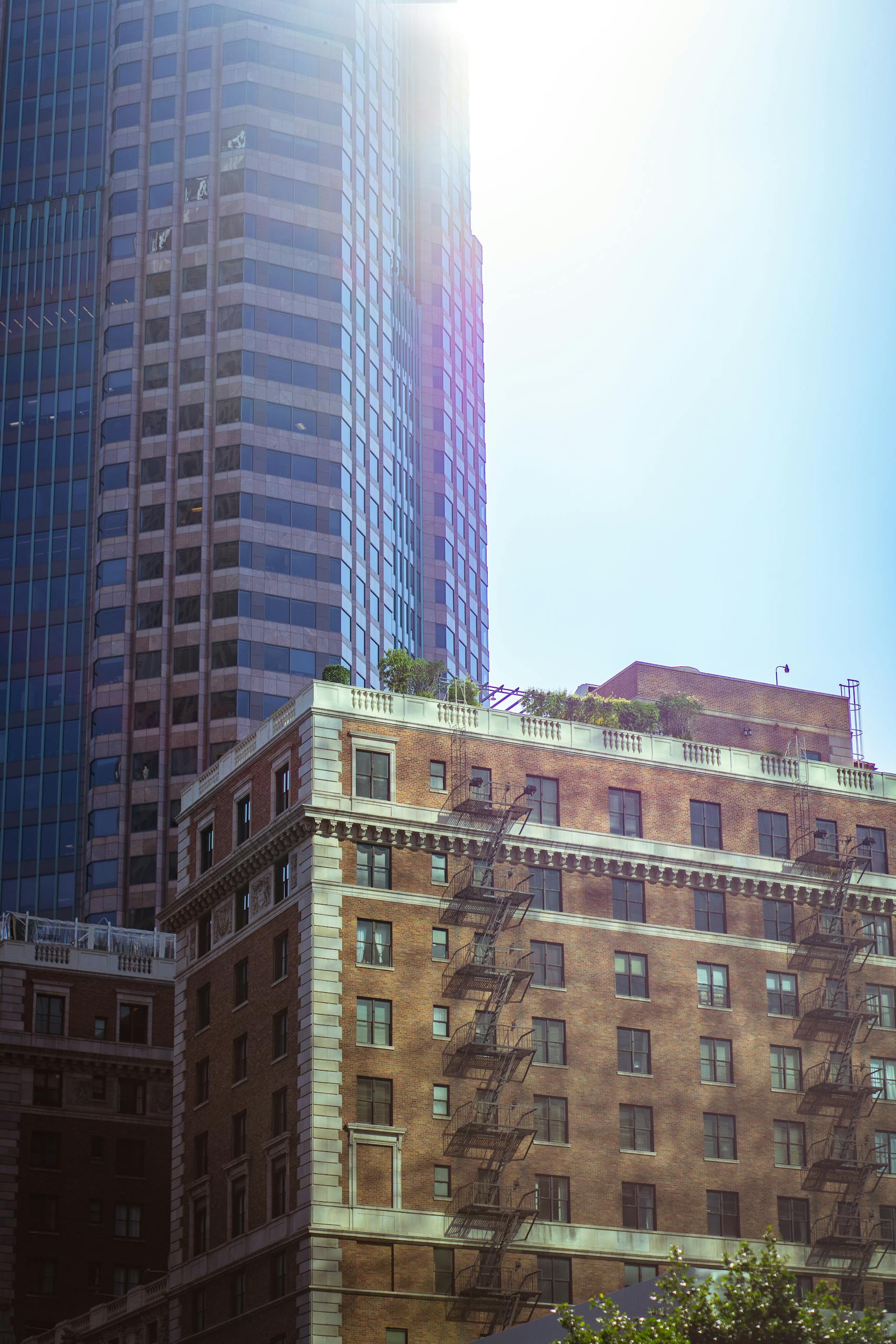 Skyscraper in downtown Los Angeles with fire escapes and blue sky backdrop.